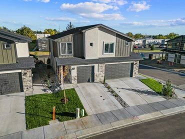Modern duplex with attached garages and freshly landscaped yards.