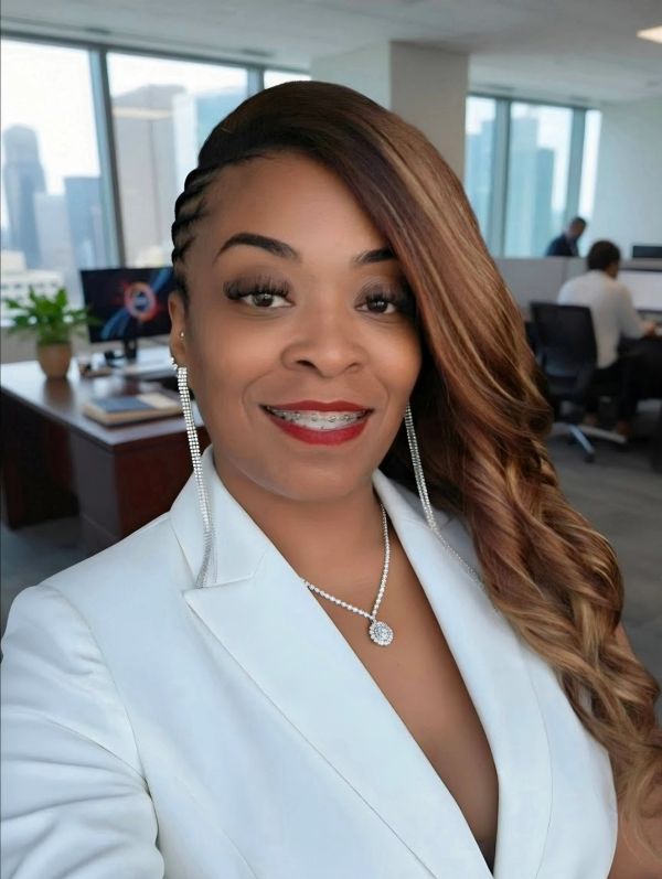 Smiling woman in white blazer with long earrings in an office.