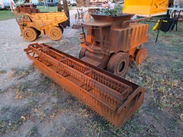 Rusty metal model of a combine harvester and dump truck.