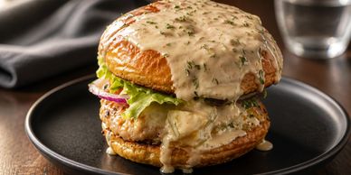Juicy chicken burger with creamy sauce on a rustic bun.