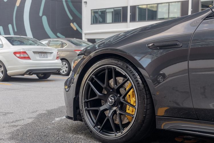 Close-up of a black Mercedes-AMG wheel with yellow brake caliper.