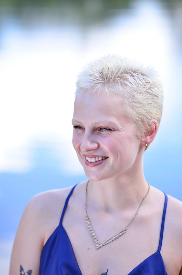 A headshot of a young blonde woman with short hair