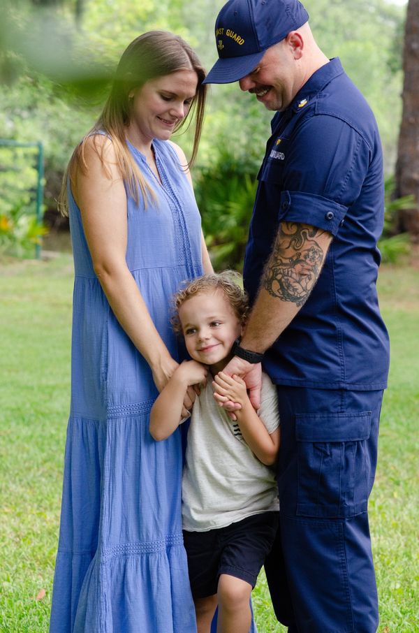 A family portrait of a couple and their son with the husband dressed in his military uniform