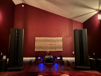High-end stereo speakers and audio equipment in a cozy room with red walls.