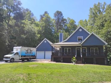 Blue house with moving truck parked outside.