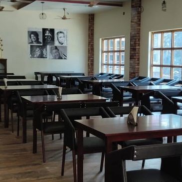 Empty dining area with wooden tables and chairs.