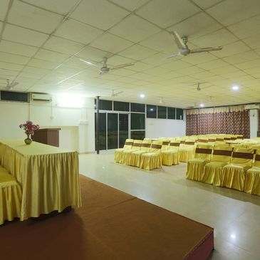 Empty conference room with chairs and tables covered in yellow cloth.