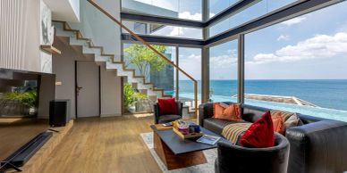 Modern living room with ocean view and glass staircase.