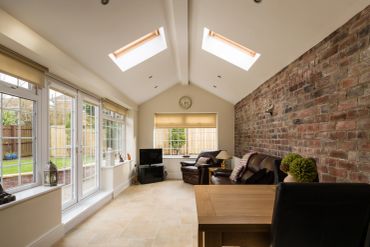 Bright room with large windows and brick wall.