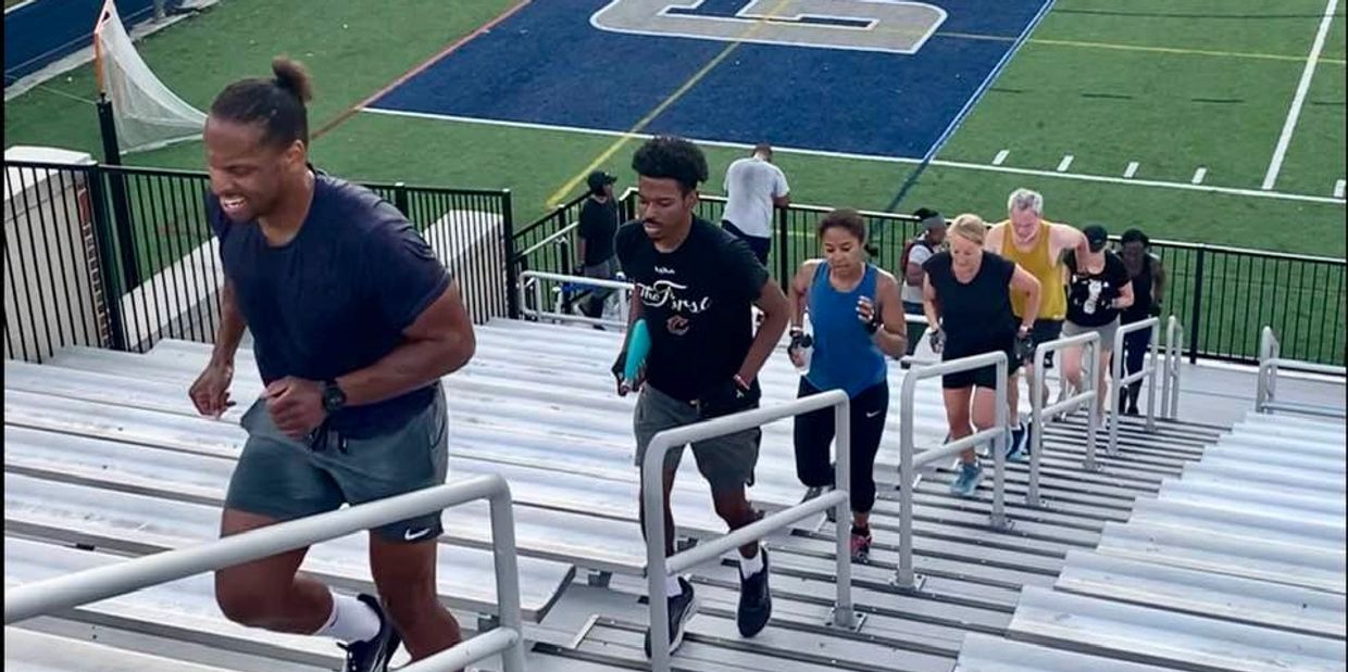 Fitness boot camp class running the stadium stairs