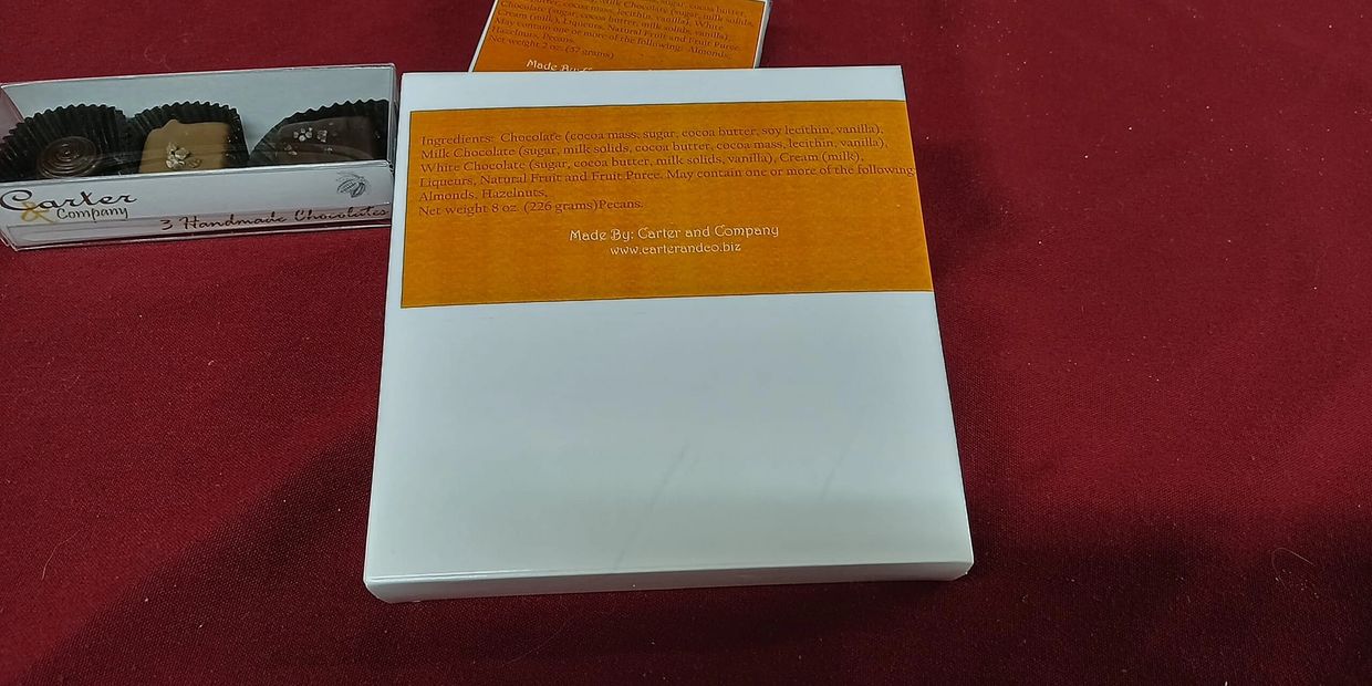 Handmade chocolate box with ingredients list on a red surface.