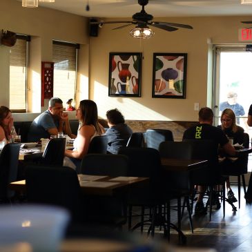 People dining in a cozy restaurant at sunset.