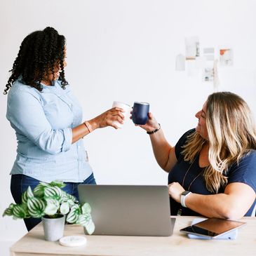Two women toasting coffee excited about small business marketing success