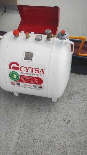 White gas cylinder with red CYTSA branding and safety valve on a rooftop.