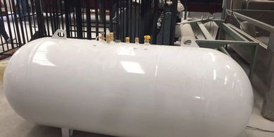 Large white industrial storage tank in a facility.