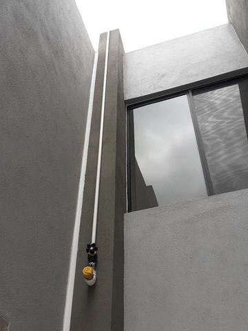 Modern architectural corner with clean lines and a reflective window.