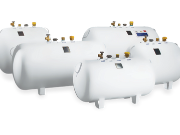 Four white industrial storage tanks with valves and gauges.