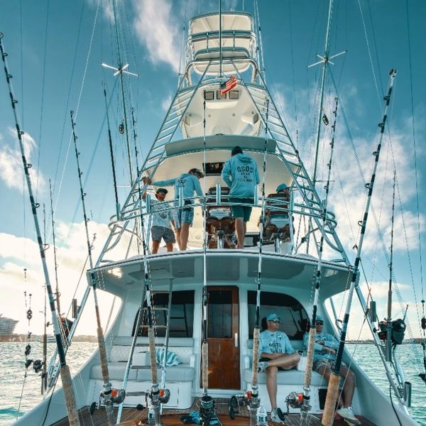 Group fishing trip on a well-equipped boat under a clear sky.