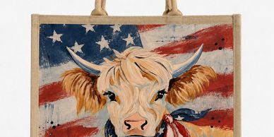 A tote bag with a cow and American flag design.