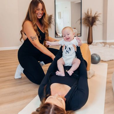 Two women and a happy baby enjoying a playful moment indoors.