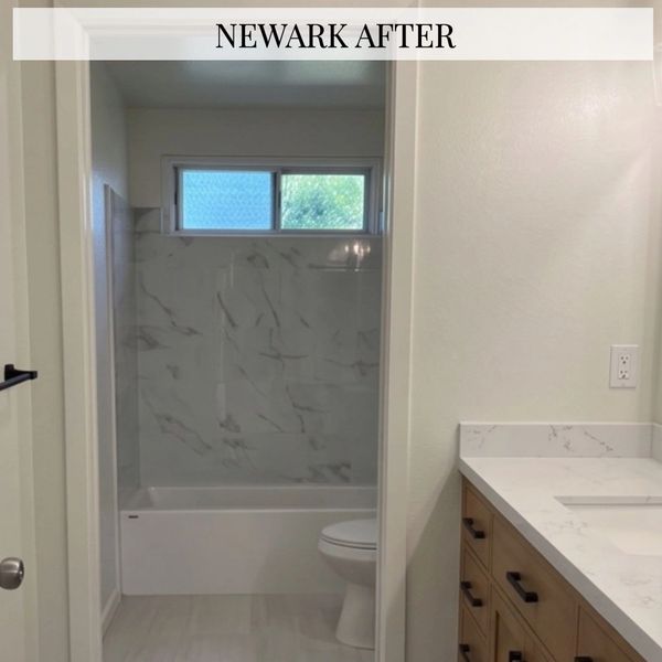 Bright, modern bathroom with marble accents and wooden cabinetry.