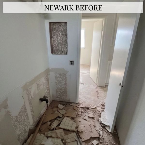 Room in Newark before renovation, showing damaged walls and floor.