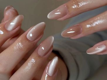 Glossy nude almond-shaped nails with a subtle shimmer.