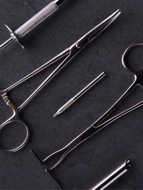 Close-up of surgical instruments on a dark surface.