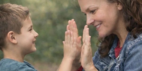 Child and woman sharing a happy moment with a high-five.