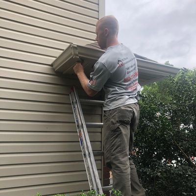 A technician fixing a mitre on a gutter, ensuring a secure connection between the gutter sections. 