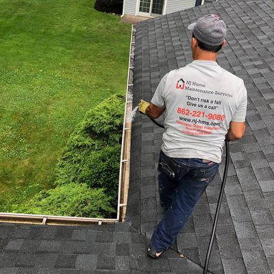Flushing out Gutter during gutter cleaning services via water hose