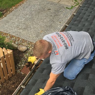 NJ Home Maintenance Services tech removing dirt & leaves during gutter cleaning, Fairfield NJ 07004