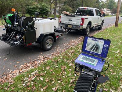 NJ Home Maintenance Services truck with drain jetting trailer and underground drain camera