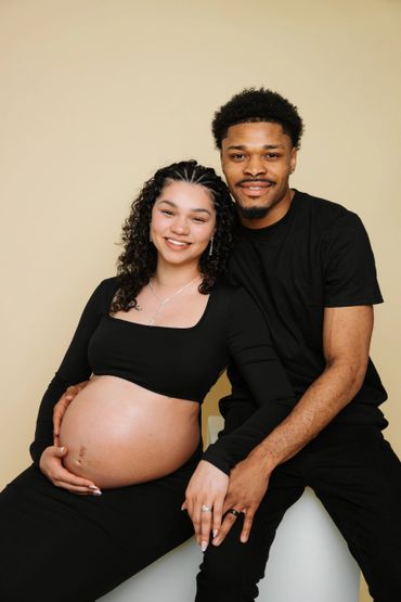 Happy couple celebrating pregnancy with smiles and hand-holding.