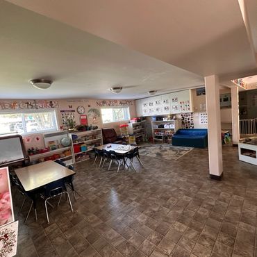 Spacious and organized early childhood classroom with learning materials and play area.
