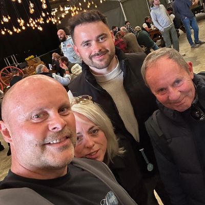 Four people smiling at an indoor event.