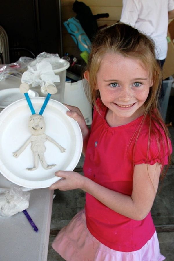 student holding clay sculpture