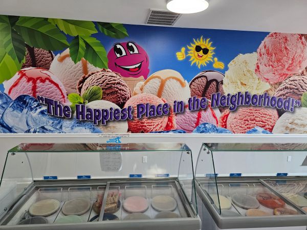 Colorful ice cream mural with slogan inside an ice cream shop.