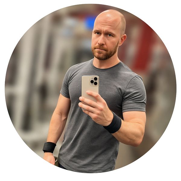 Man in gray shirt taking a selfie at the gym.