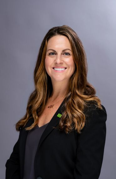 Professional woman with long hair smiling in a black blazer.