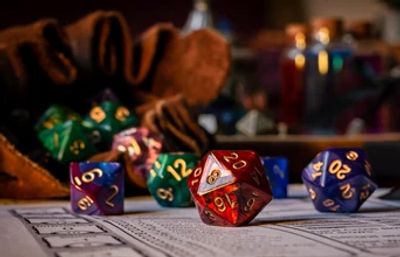 Colorful polyhedral dice scattered on a tabletop gaming sheet.