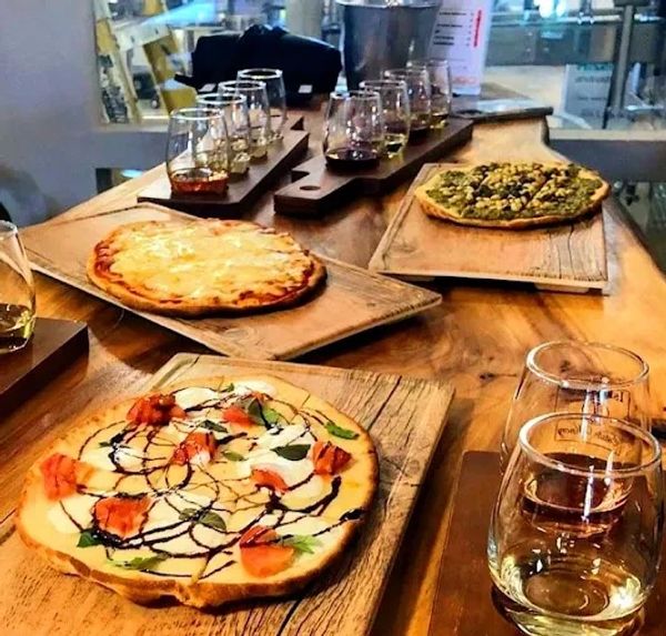 Flatbread pizzas paired with whiskey tasting flights on wooden boards.