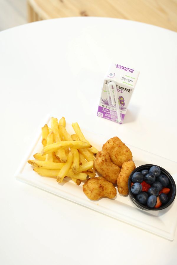 Kids' meal with nuggets, fries, fruit, and grape juice.
