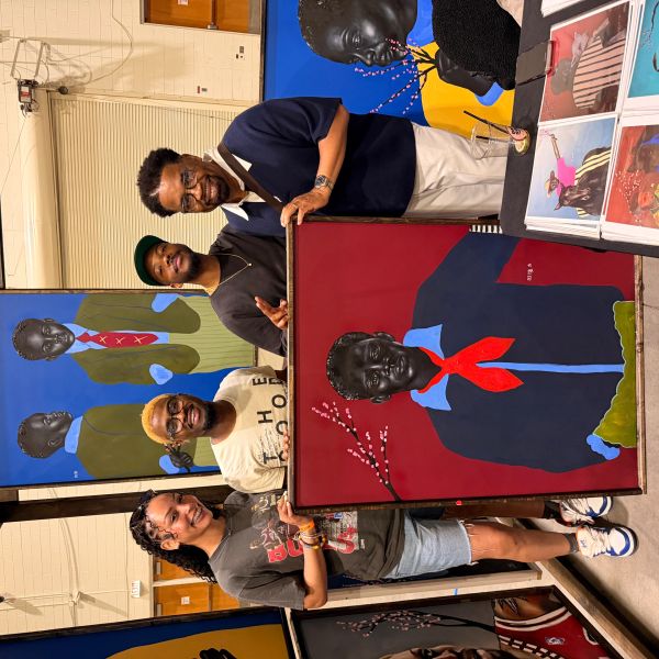 Four people proudly display vibrant, expressive paintings of young Black boys in formal attire.