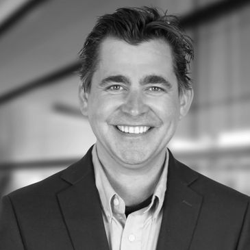 Smiling man in a blue suit jacket and light blue shirt.