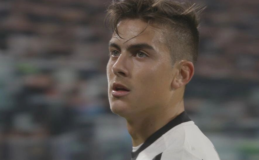 Close-up of a focused soccer player in a white and black jersey.