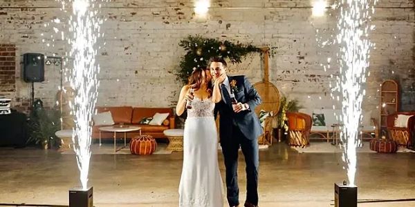 Newlyweds enjoying a champagne moment with sparklers in the background.