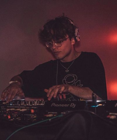 DJ mixing music in a dimly lit room.