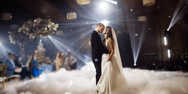 Bride and groom share a dance in a dreamy setting.