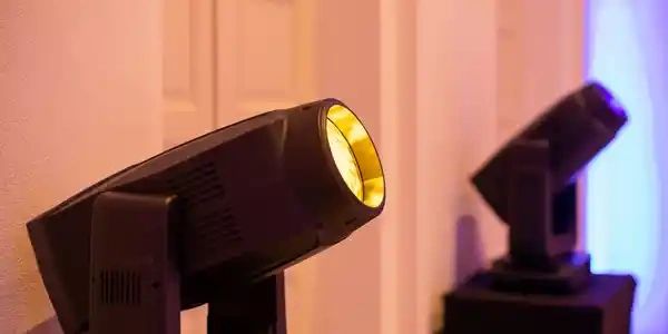 Two stage spotlights facing a wall.